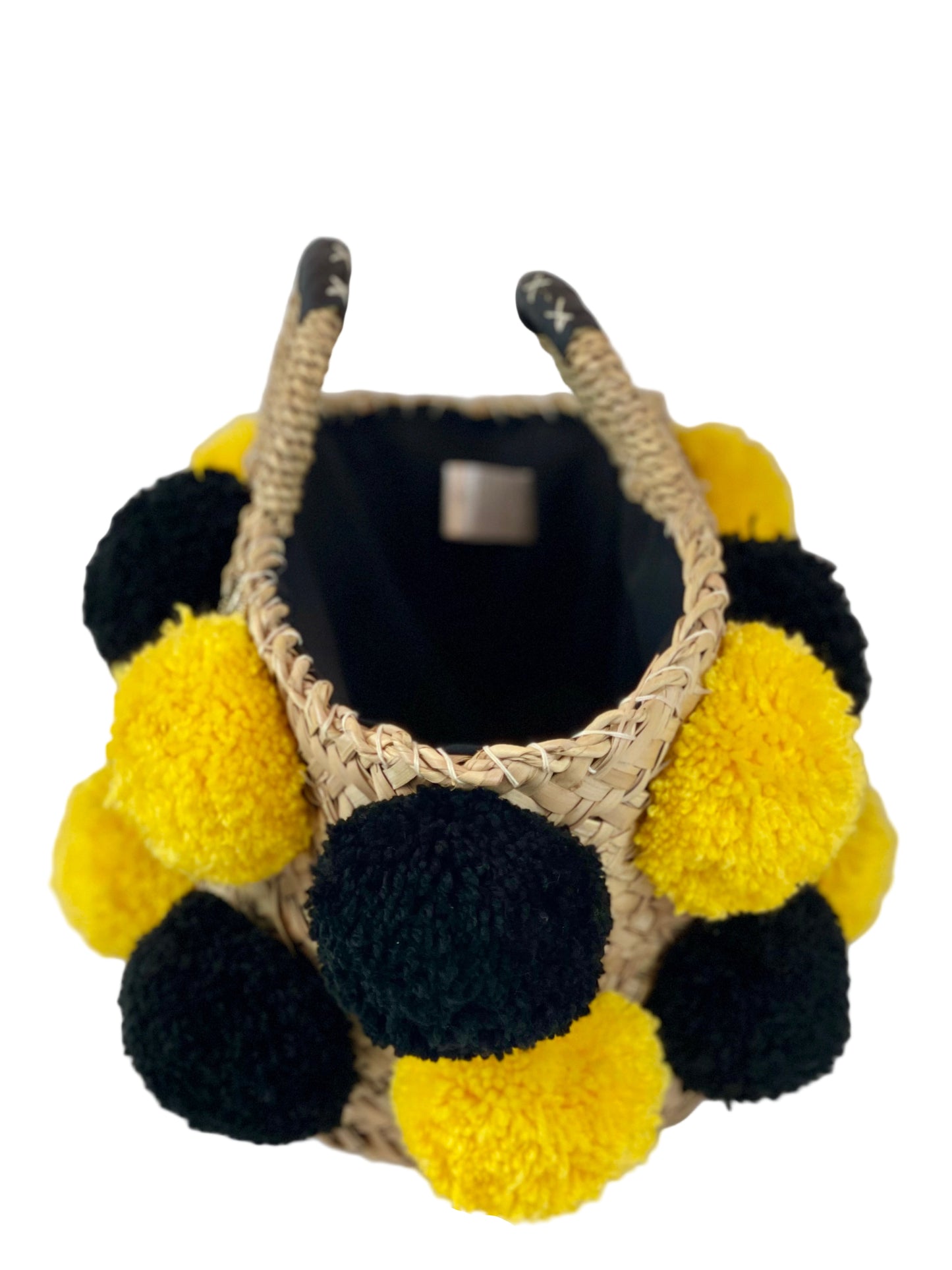 Basket with handmade yellow and black pom poms