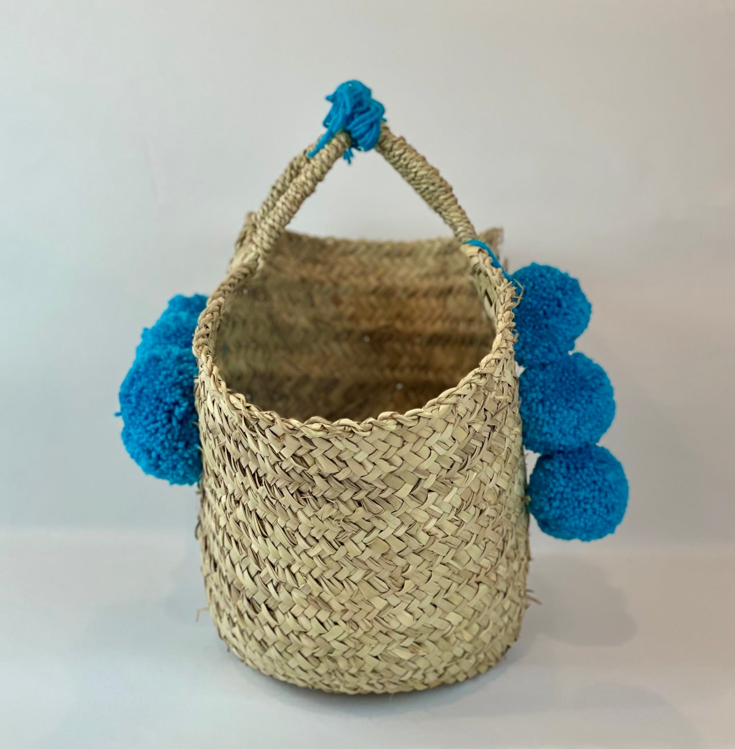 Basket with multicolored pom poms