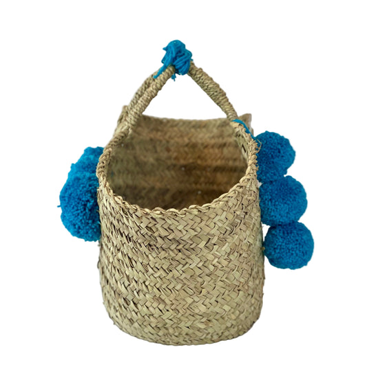 Basket with multicolored pom poms