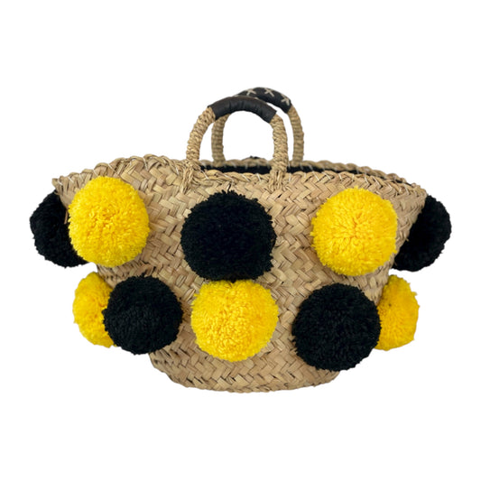Basket with handmade yellow and black pom poms