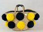 Basket with handmade yellow and black pom poms