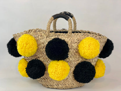 Basket with handmade yellow and black pom poms