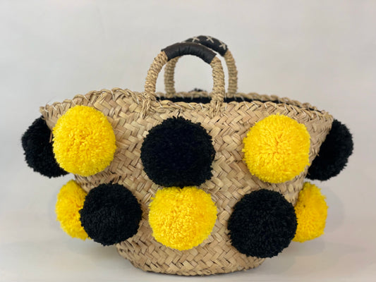 Basket with handmade yellow and black pom poms