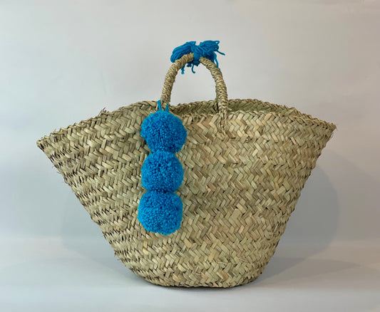 Basket with multicolored pom poms